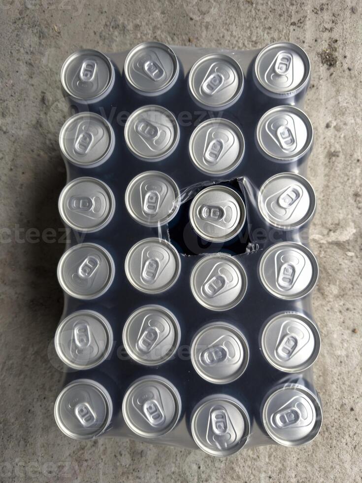 Collection of soda cans arranged in a uniform pattern on a surface photo
