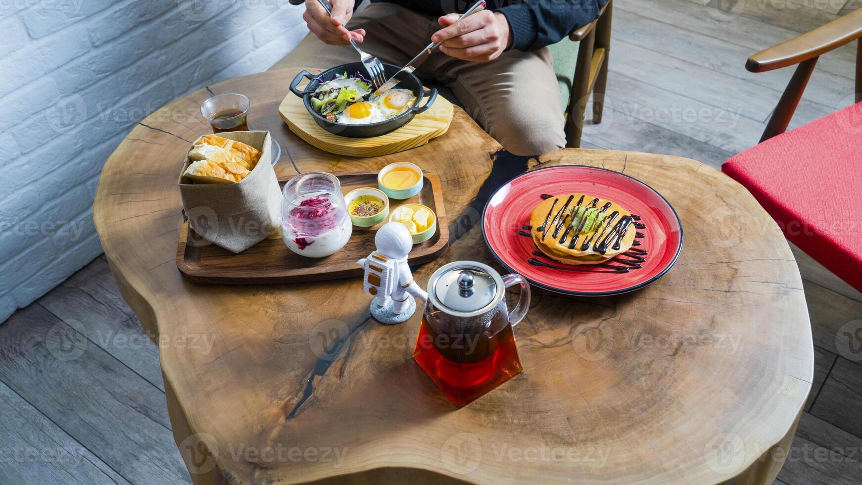 Enjoying a hearty brunch with eggs, dessert, and coffee on a wooden table photo