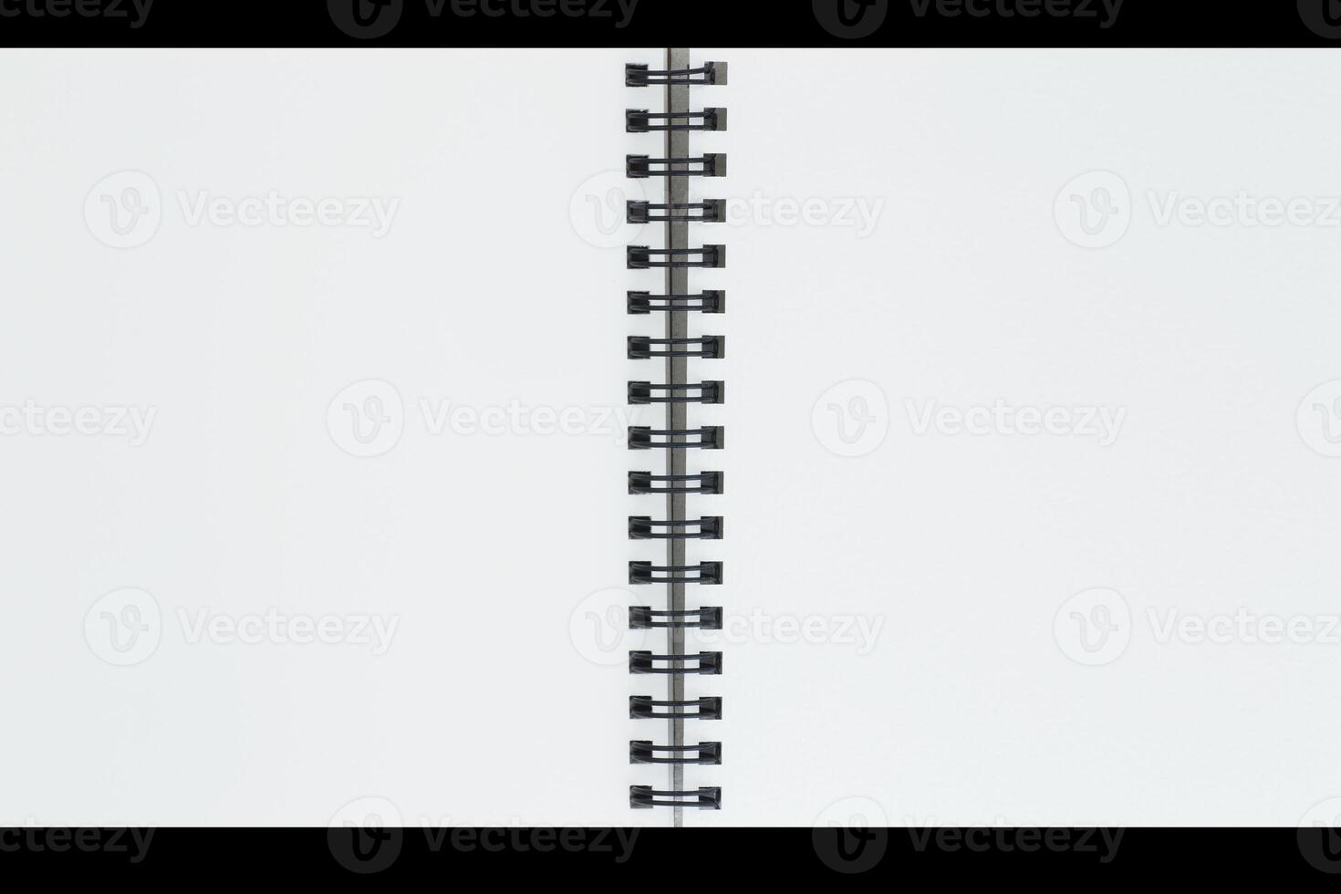 close up of two blank pages of sketch book with spiral bound against black photo