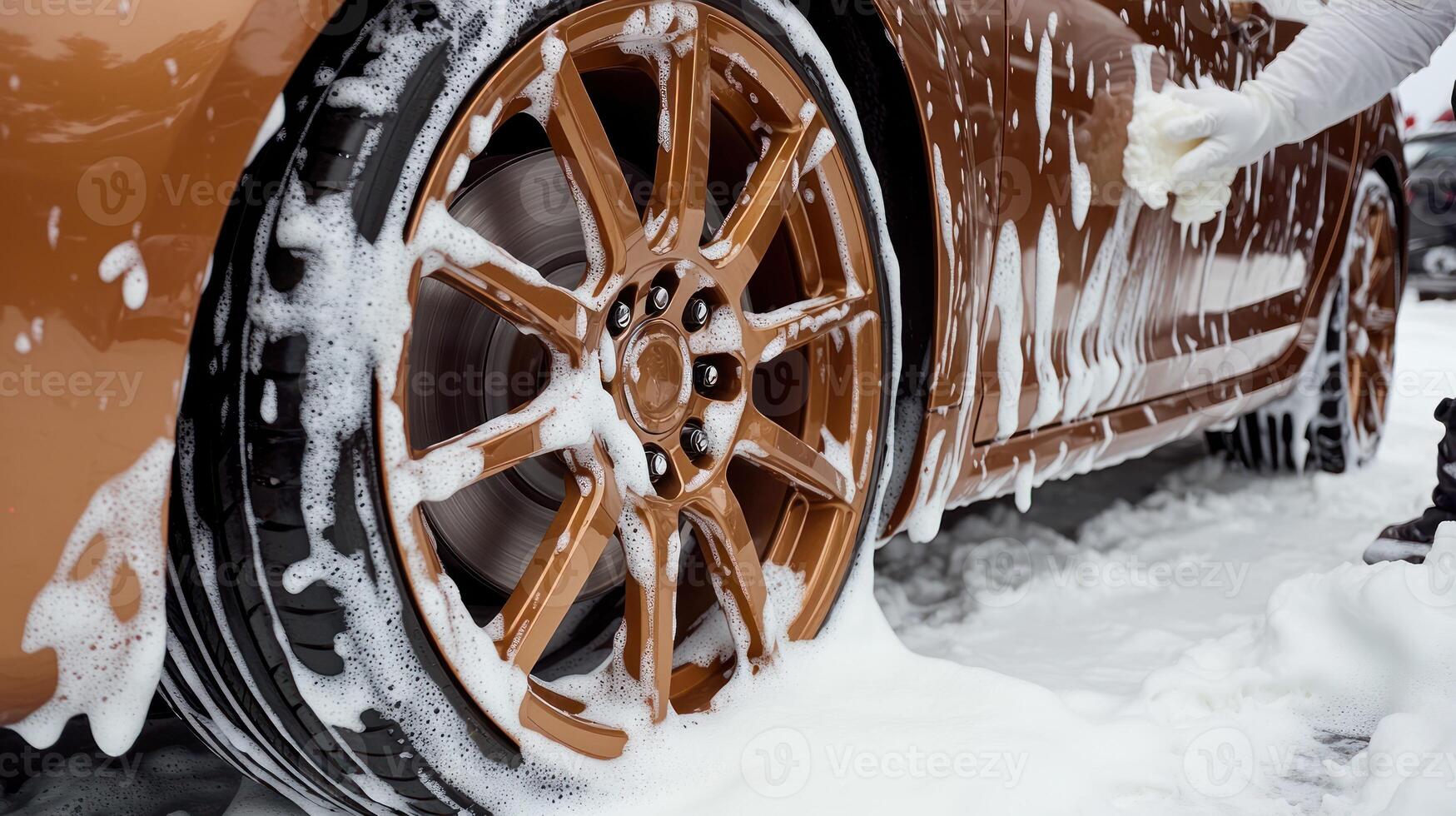 Person details the vibrant orange car, washing its stylish wheels covered in foam on a sunny day photo