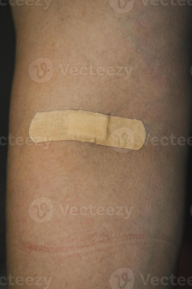 Band-aid on an arm indicating a recent minor injury or scrape photo