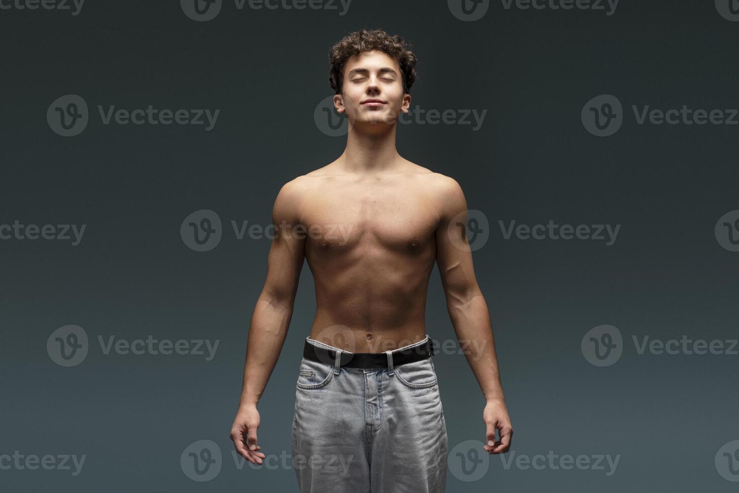 Smiling, attractive athlete, young teen boy with bare torso with closed eyes, closed eyes photo