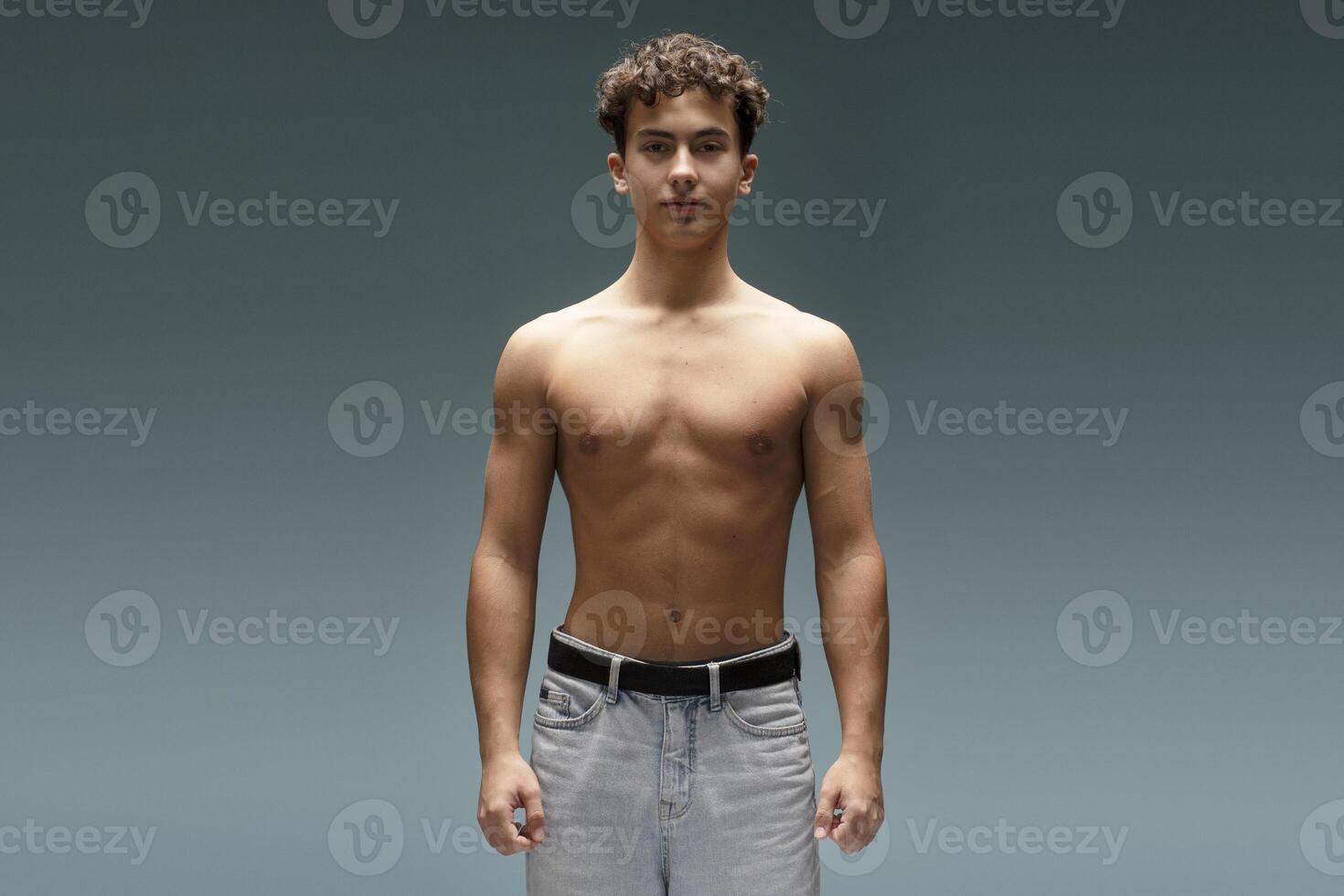 Young, attractive teen boy with naked torso, bare body, looking at camera, fashion model photo