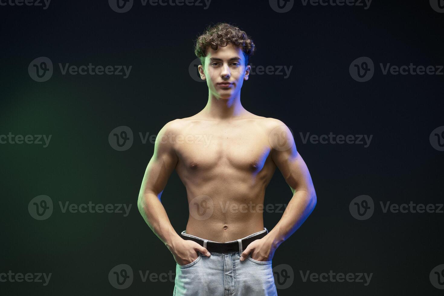 Confident, attractive teen boy with naked torso, bare body, looking at camera, fashion model photo