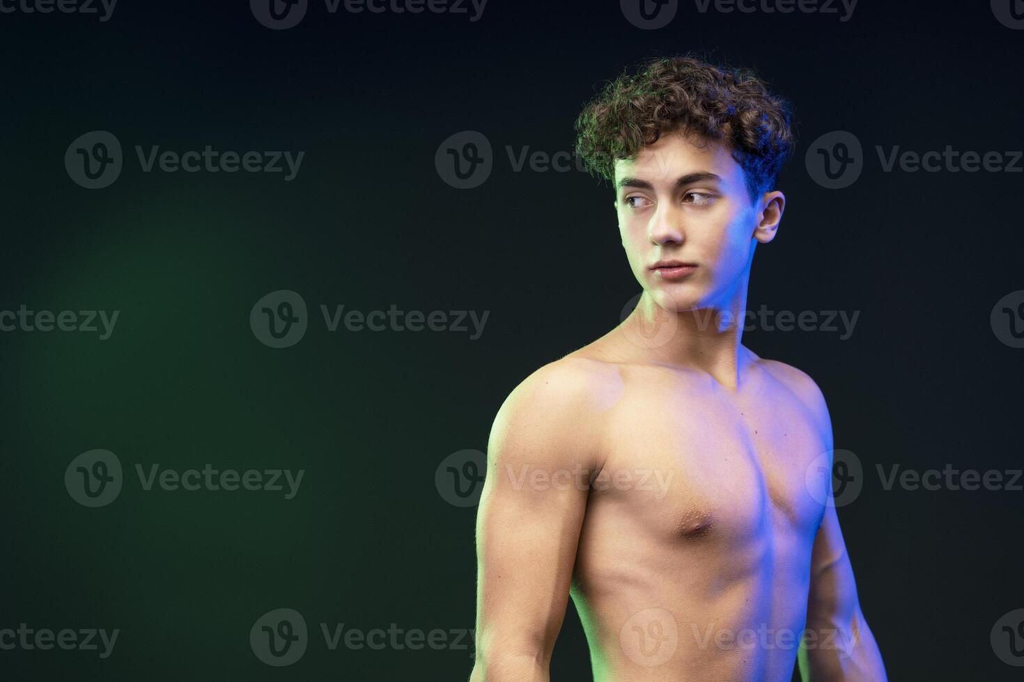 Portrait of serious, pensive young boy, teenager with bare torso, looking away on copy space photo
