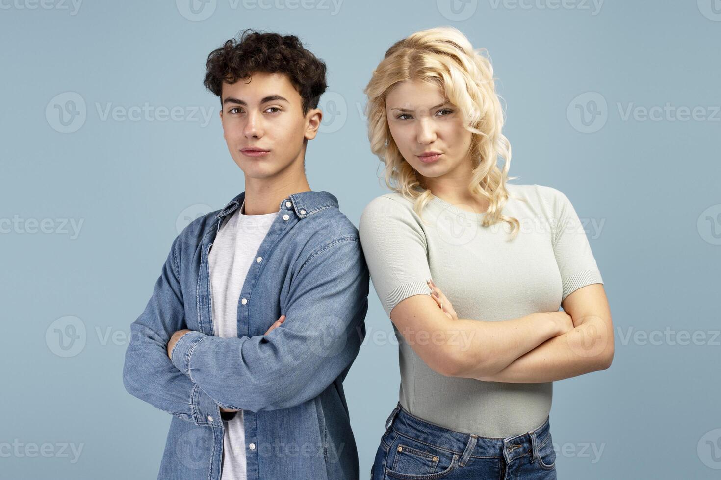 Portrait of friends, young couple, fashion models wearing casual clothes with crossed arms together photo