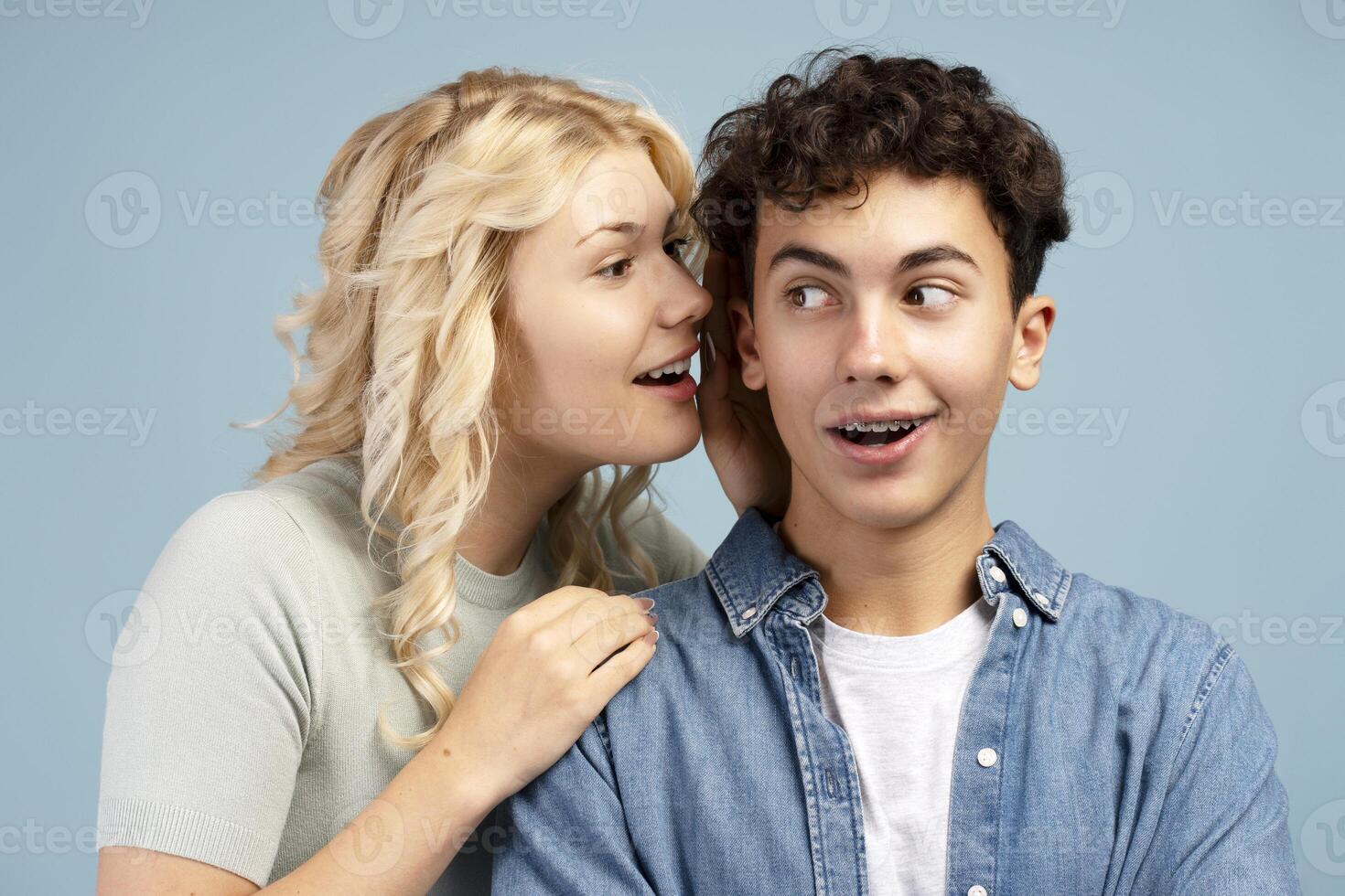 Portrait of happy attractive couple teen boy and girl girlfriend whispers to boyfriend with brackets photo