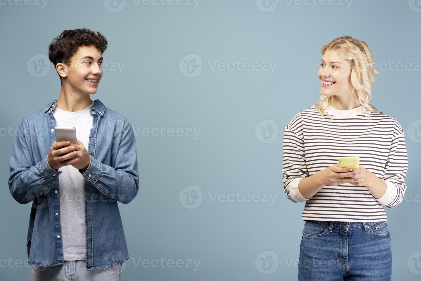 Positive, young boy and girl holding mobile phone, using mobile app, chatting, online shopping photo