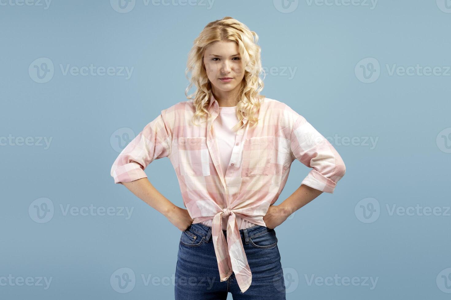 Portrait of angry, serious, pensive teenager wearing casual clothes hands on sides photo