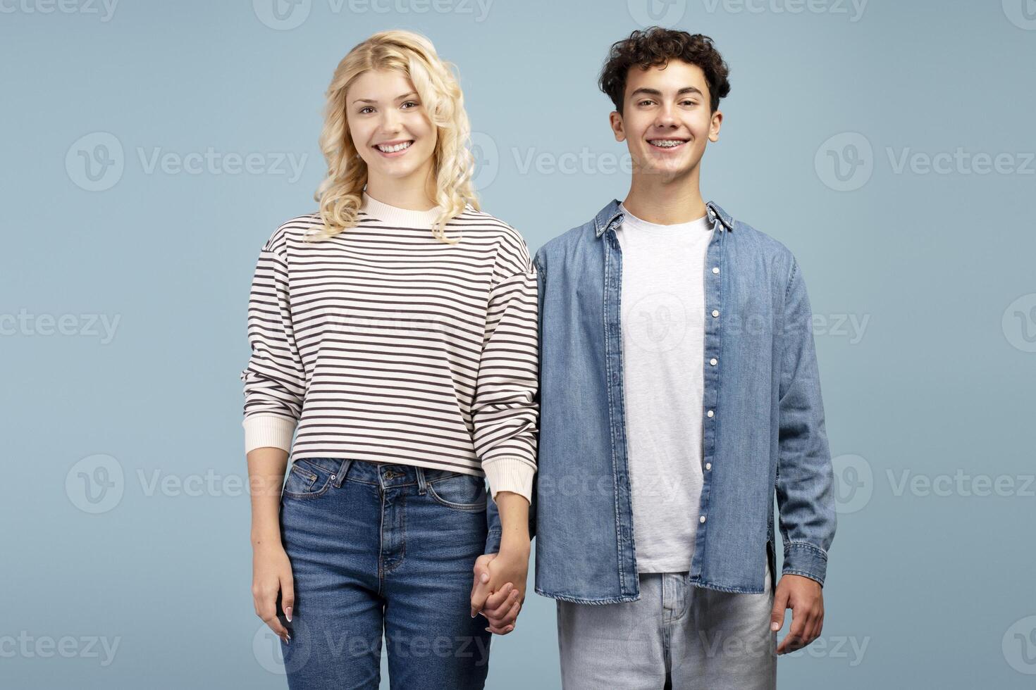 Positive teenagers, young couple, smiling boyfriend and girlfriend holding hands each other photo