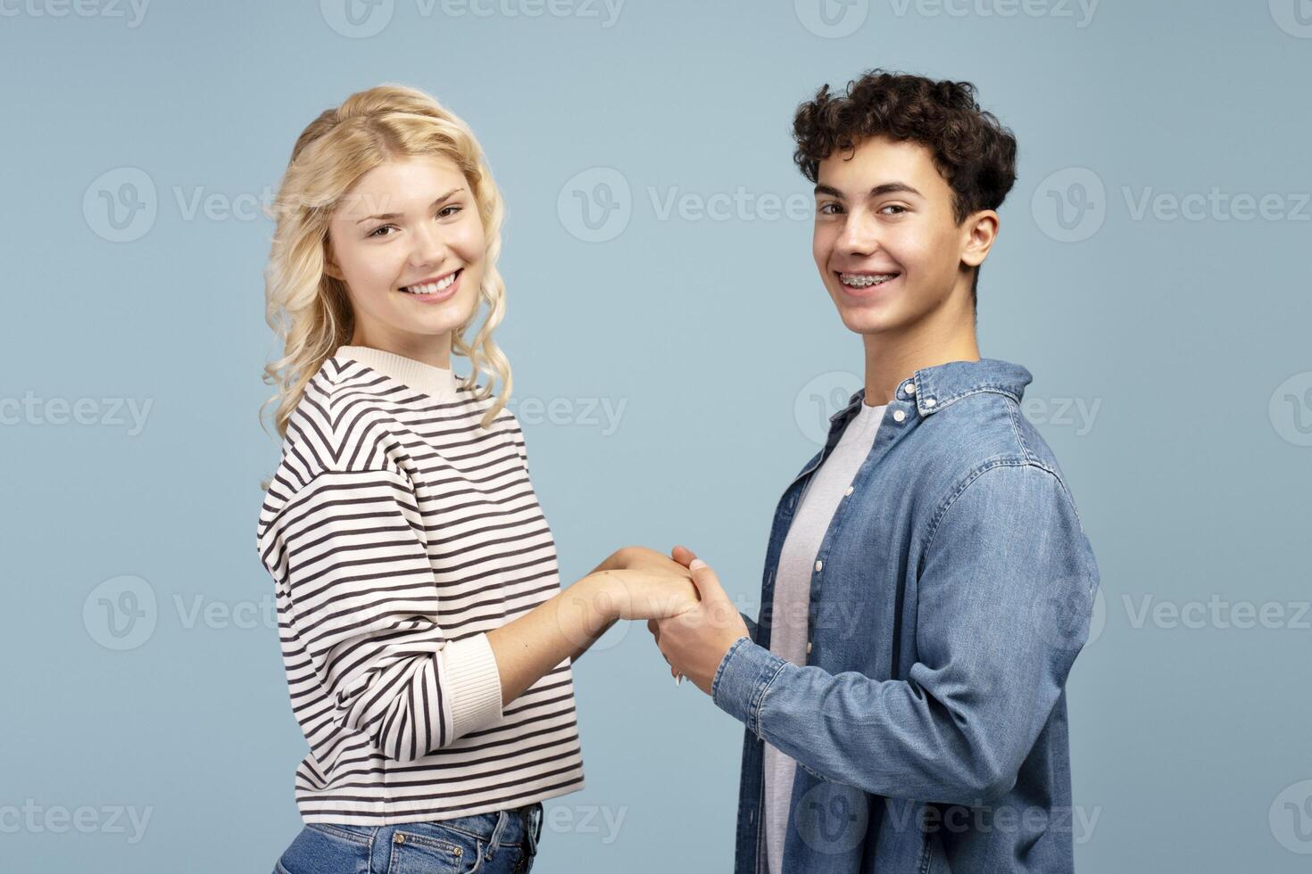 Happy, attractive young couple, smiling boy and girl wearing casual clothes holding hands each other photo