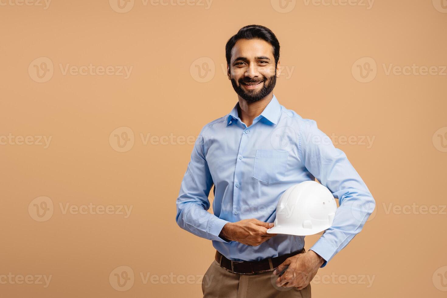 Smiling, confident, attractive Middle aged man, engineer holding white hard hat, looking at camera photo