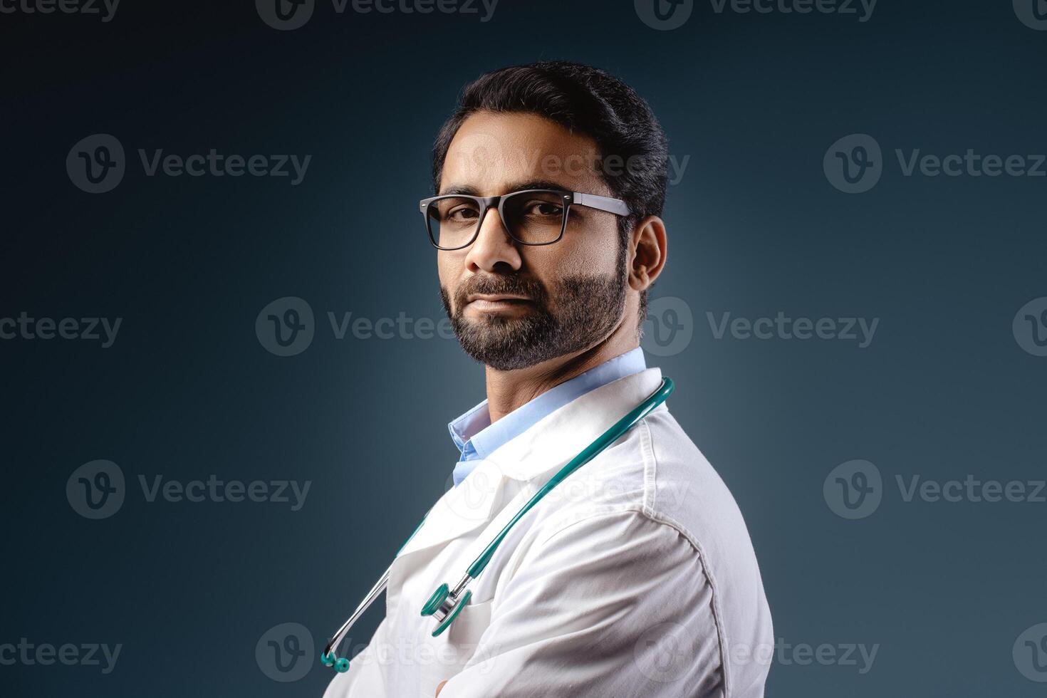Portrait of serious, pensive Indian man, professional doctor wearing white coat looking at camera photo