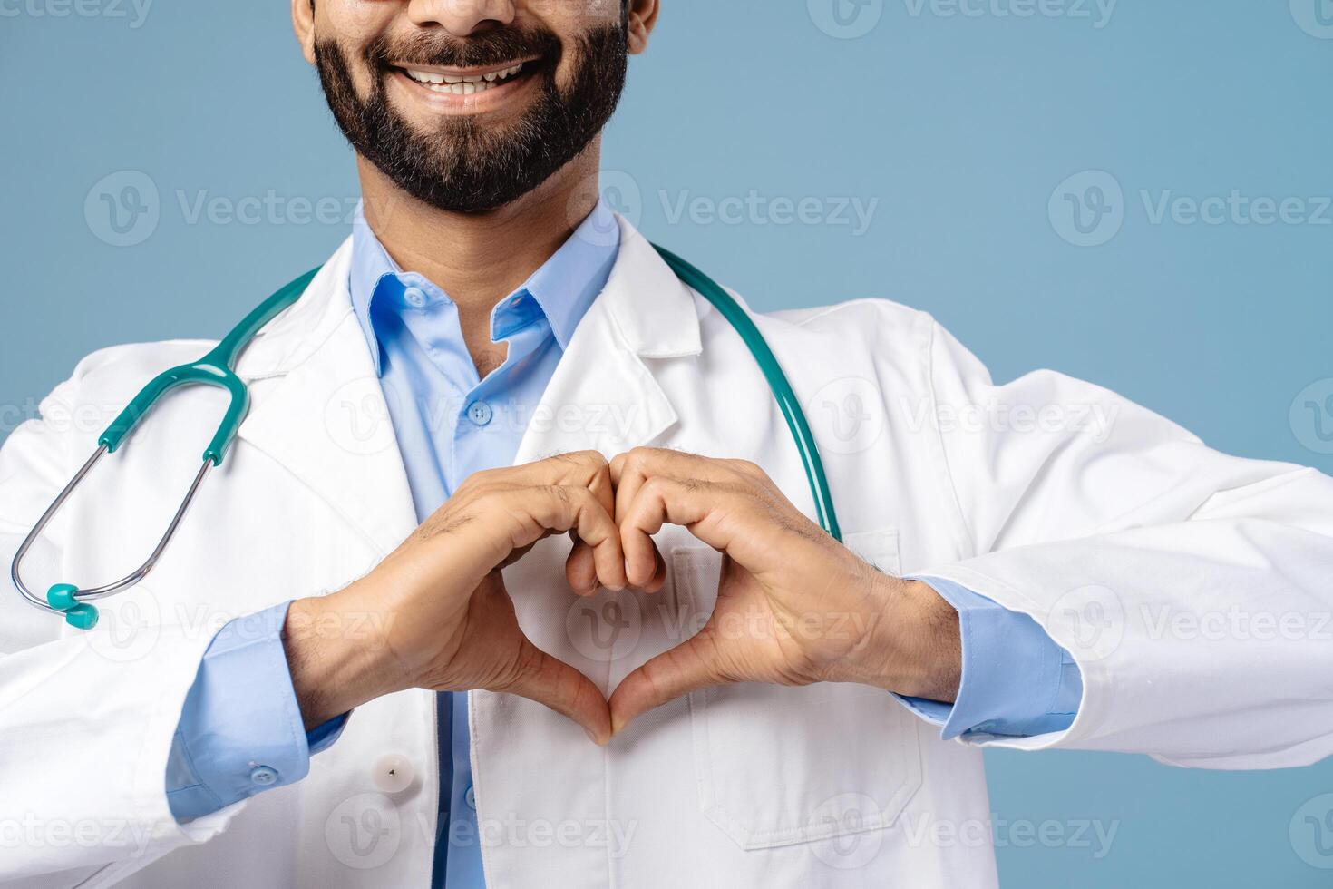 Portrait of smiling bearded Indian man professional doctor showing hearth with hands selective focus photo