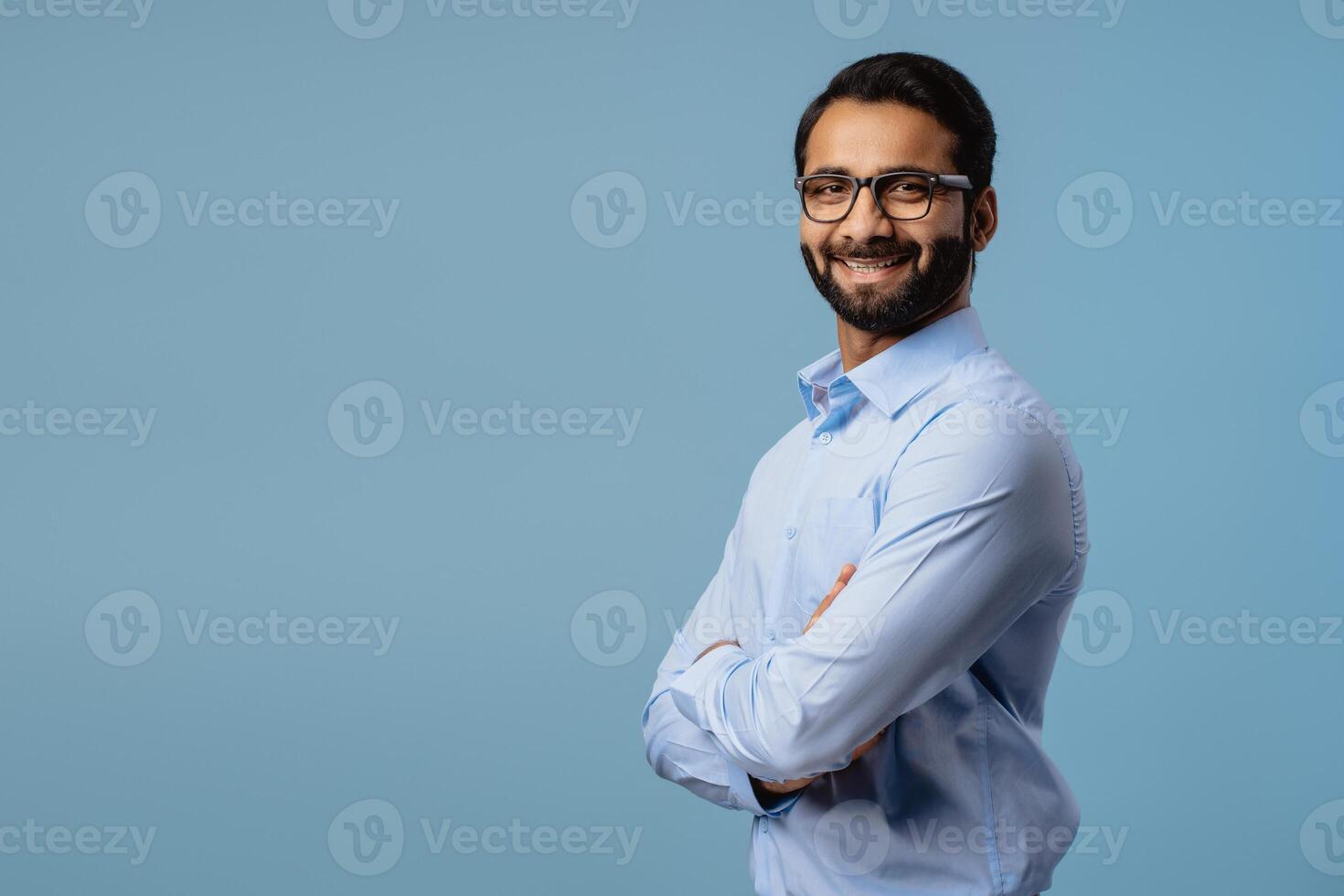 Portrait of smiling, happy Indian man wearing stylish eyeglasses looking at camera, copy space photo