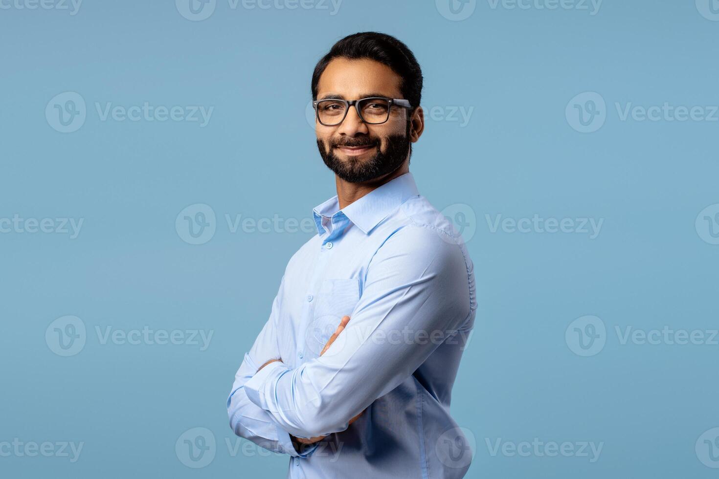 Successful, handsome middle aged Indian man wearing stylish eyeglasses with crossed arms photo