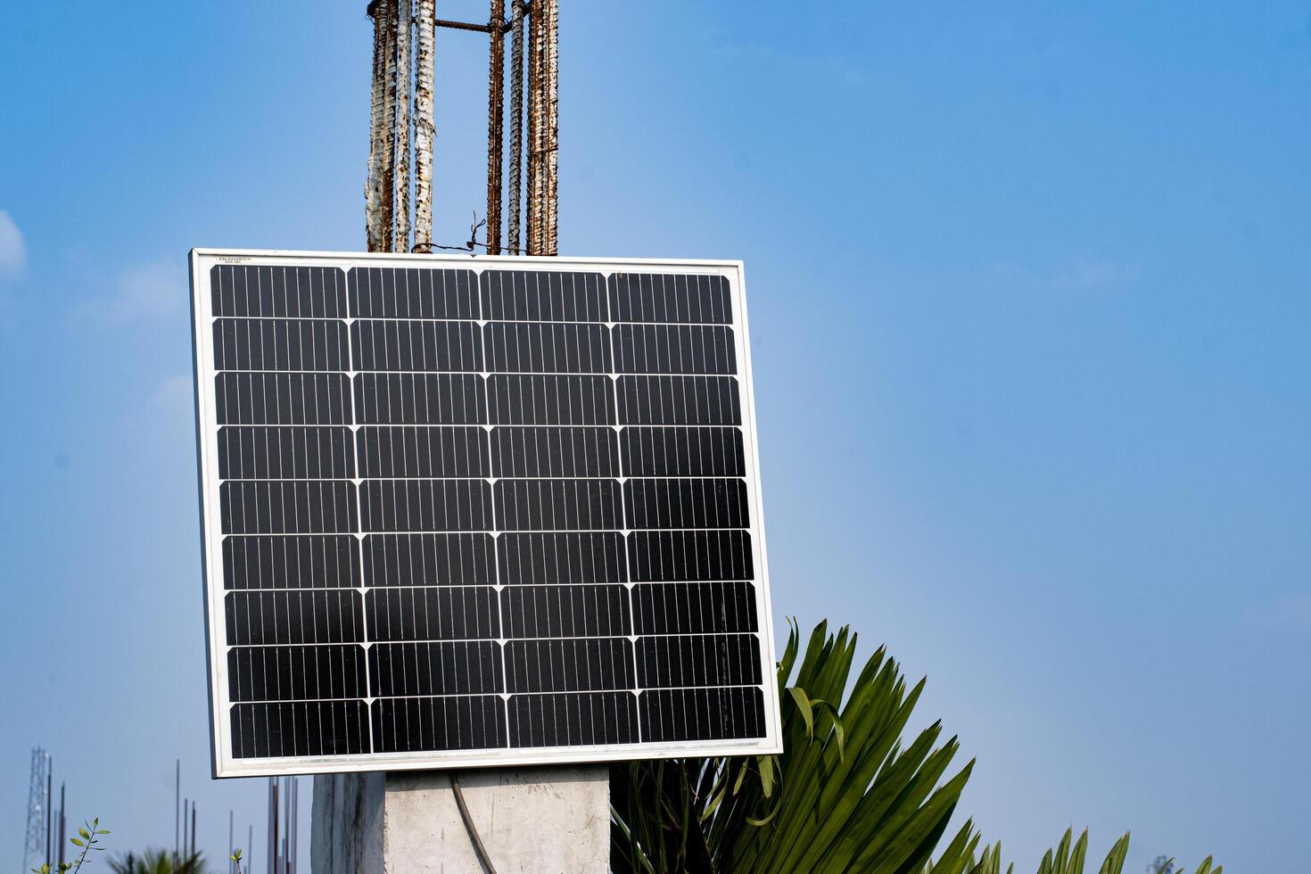 Rooftop solar panel hanging on building pillar heading to the Sun photo