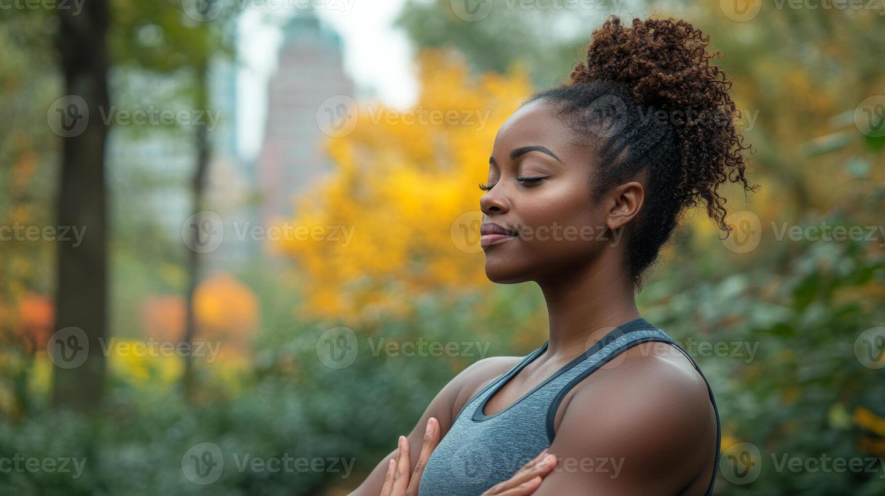 A young woman enjoys a moment of mindfulness in a serene urban park, surrounded by colorful autumn leaves and gentle nature. She appears relaxed and focused. photo