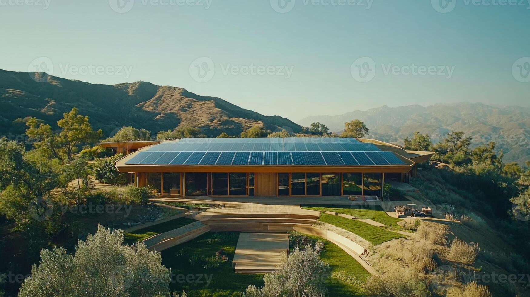 This modern structure, situated in a mountainous region, showcases solar panels atop its roof. photo