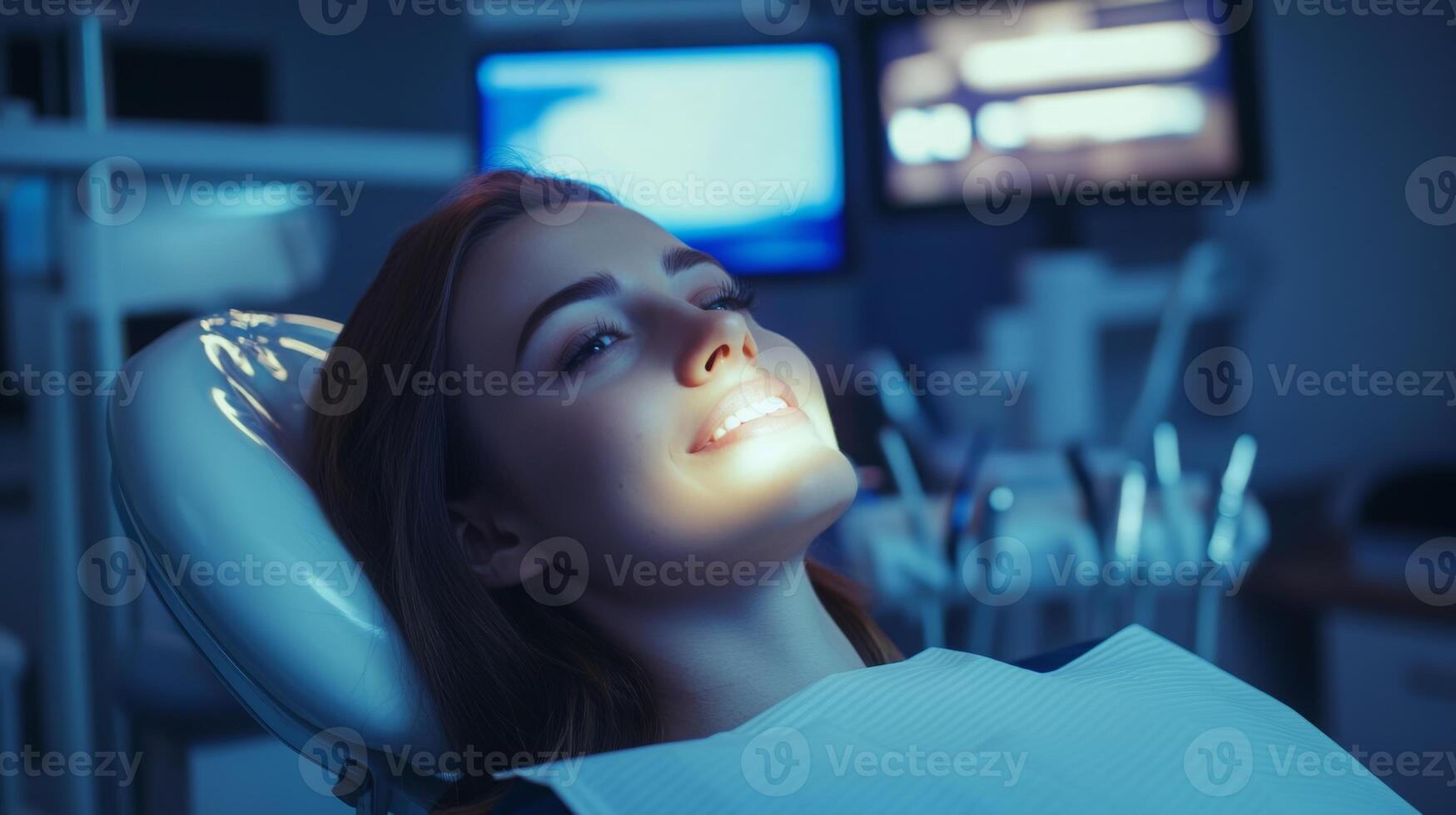 A patient sits comfortably in a dental chair while undergoing treatment in a state-of-the-art clinic. The atmosphere is enhanced by ambient lighting and advanced equipment visible in the background. photo
