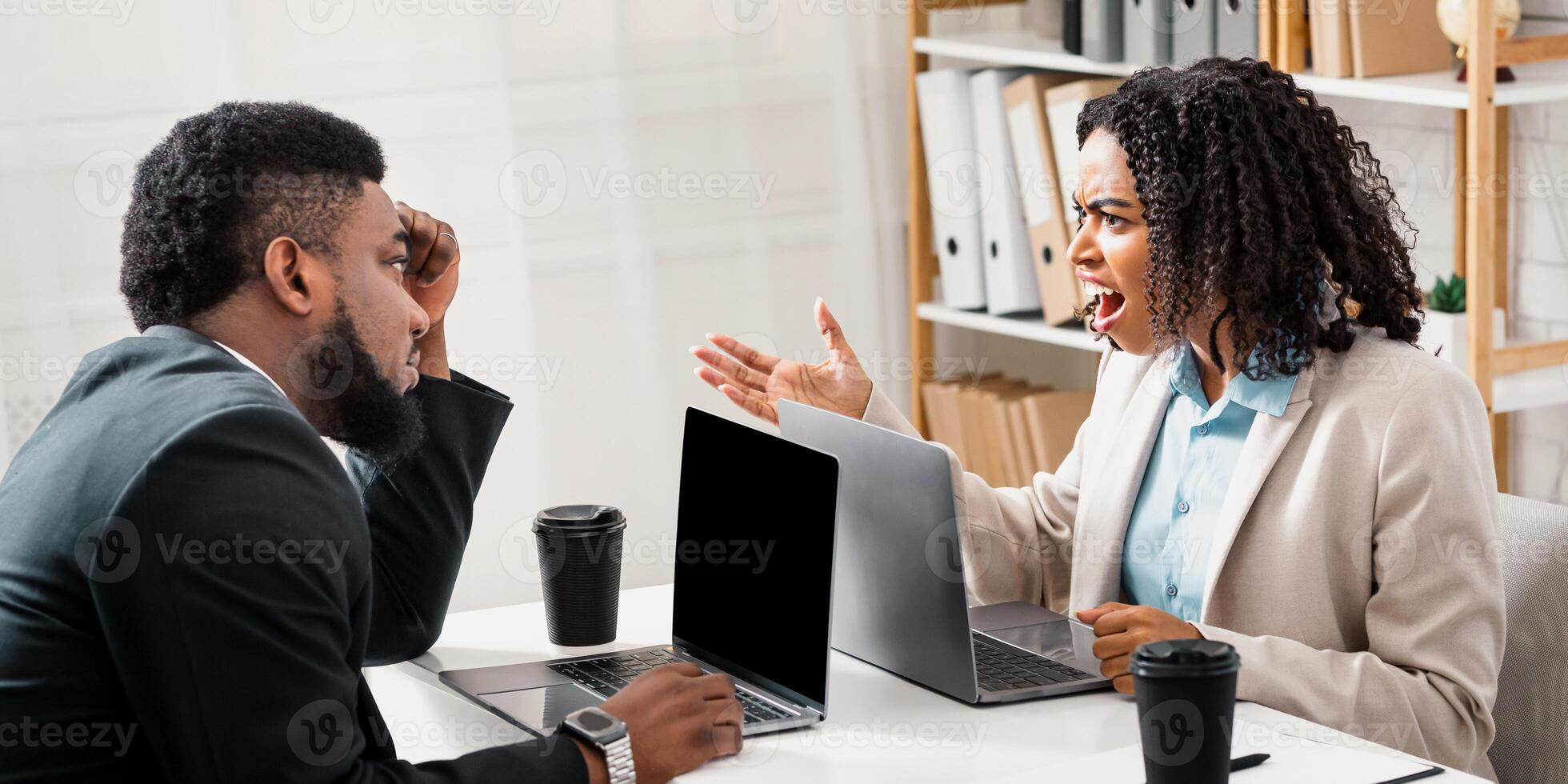 Angry African American woman having fight with her collague at company office, copy space. Millennial black lady shouting at her male coworker, having workplace conflict photo