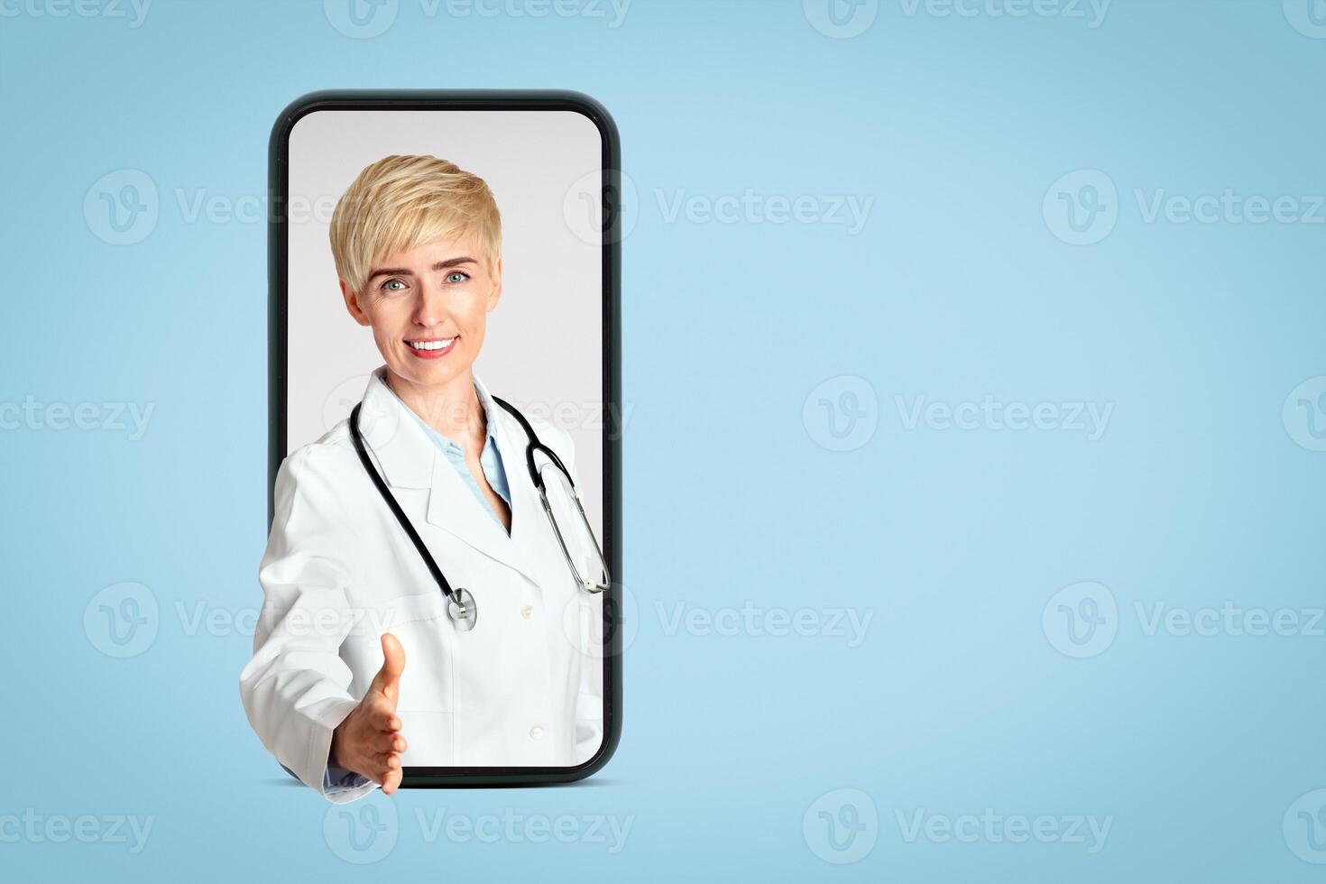 Visit to family doctor or therapist. Friendly adult female in white coat with stethoscope holds out hand for greeting patient in clinic, isolated on gray background, free space, studio shot, vertical photo