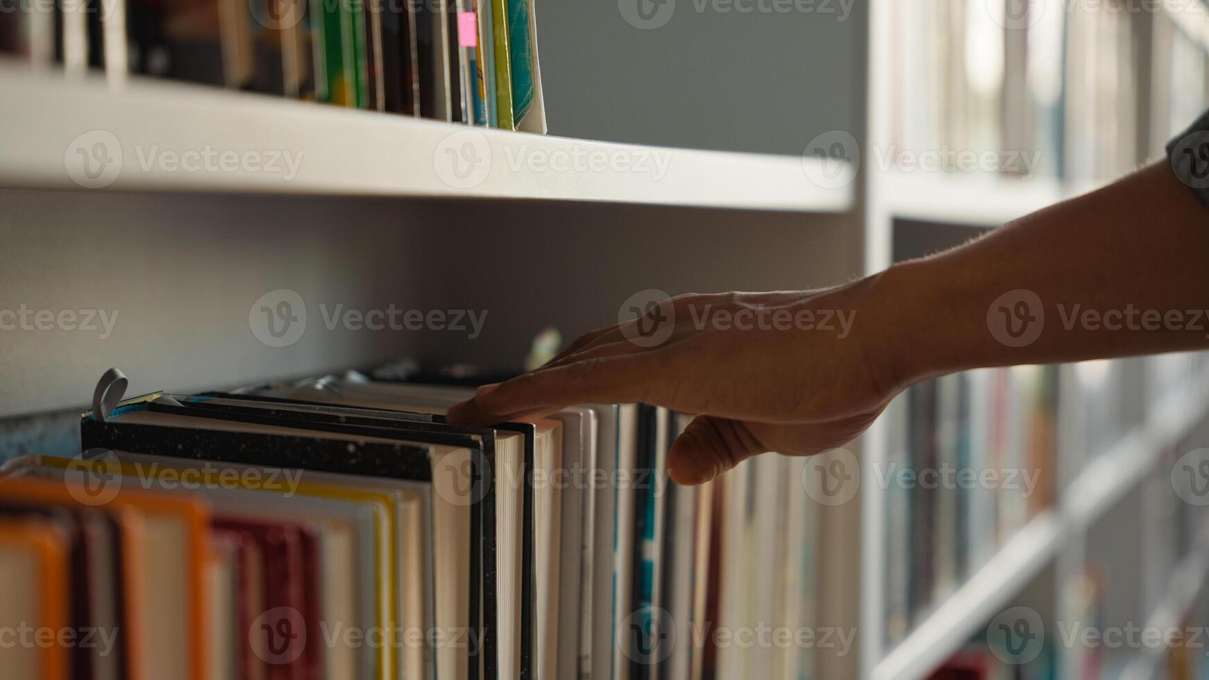 Close up hand African American man choose book bookshelf library bookstore student university unrecognizable reader literature textbooks literary bookworm bookcase education learn buyer shopper books photo