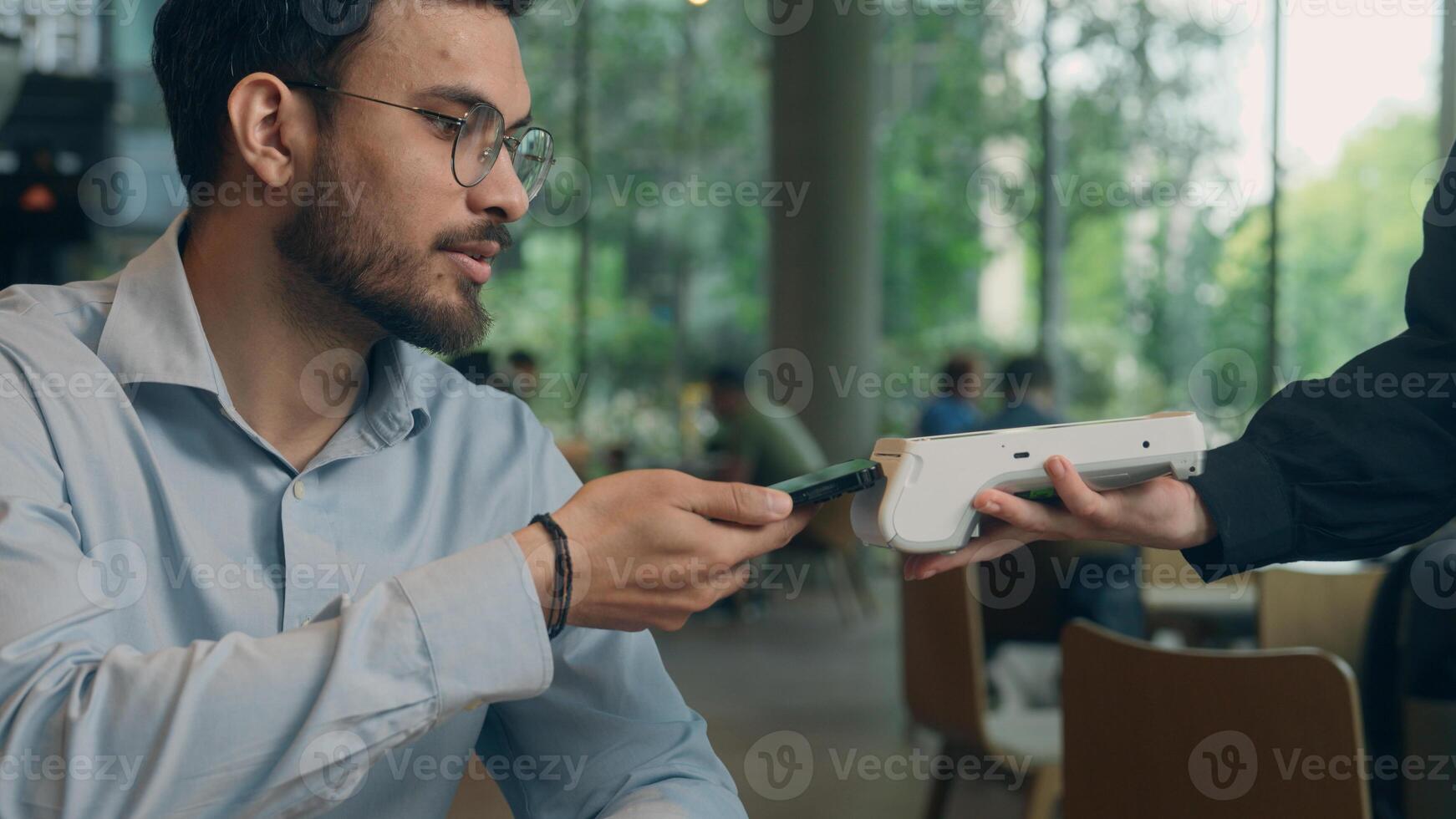 Close up hands visitor man pay bill food order in cafe restaurant unrecognizable waiter holding terminal wifi scan using smartphone contactless NFC payment cashless client service mobile phone bank photo