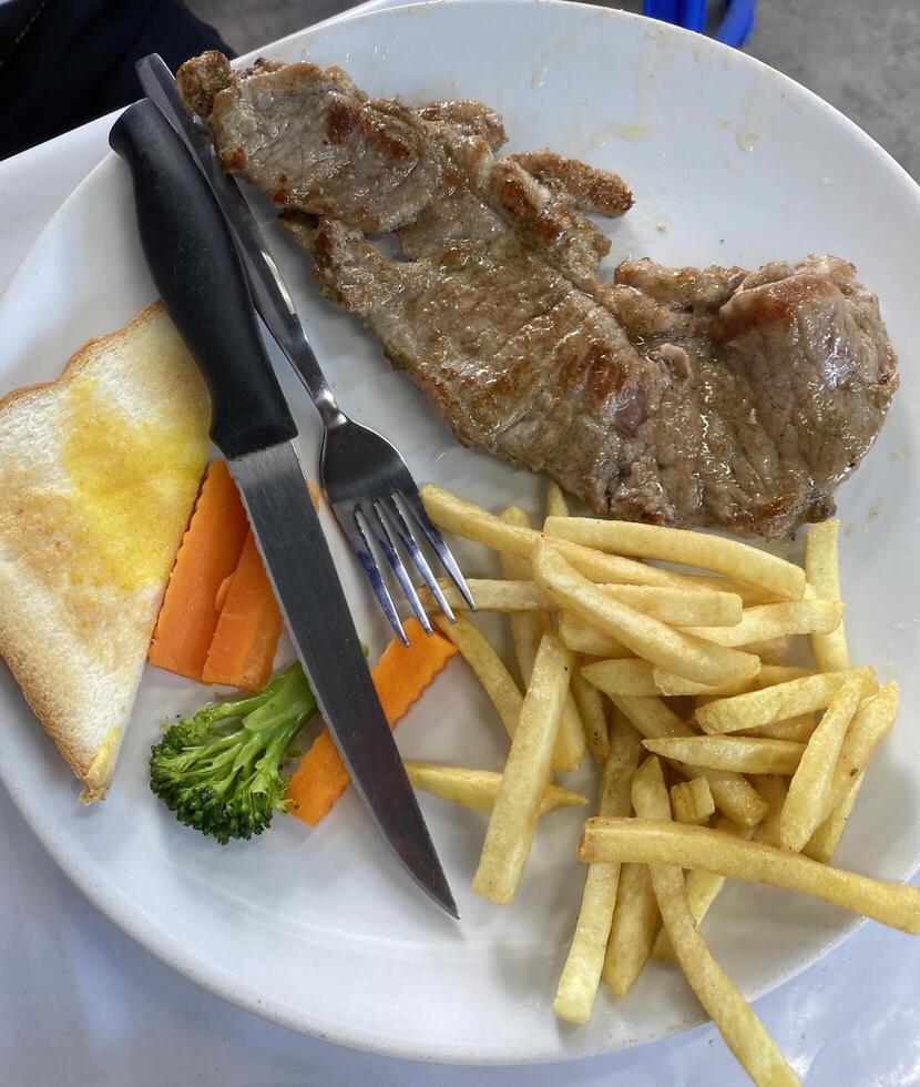 Delicious grilled steak dinner with fries and vegetables restaurant food presentation indoor setting culinary delight photo