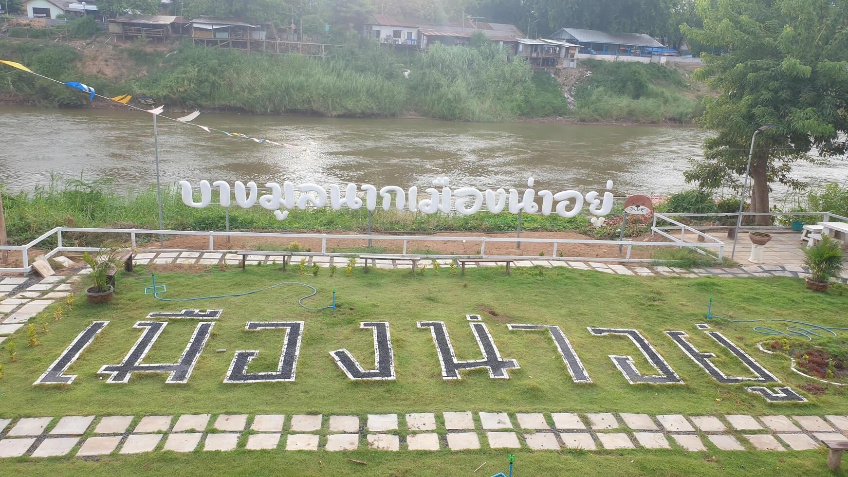 Scenic riverbank view community park grass signage rural landscape aerial perspective nature appreciation photo