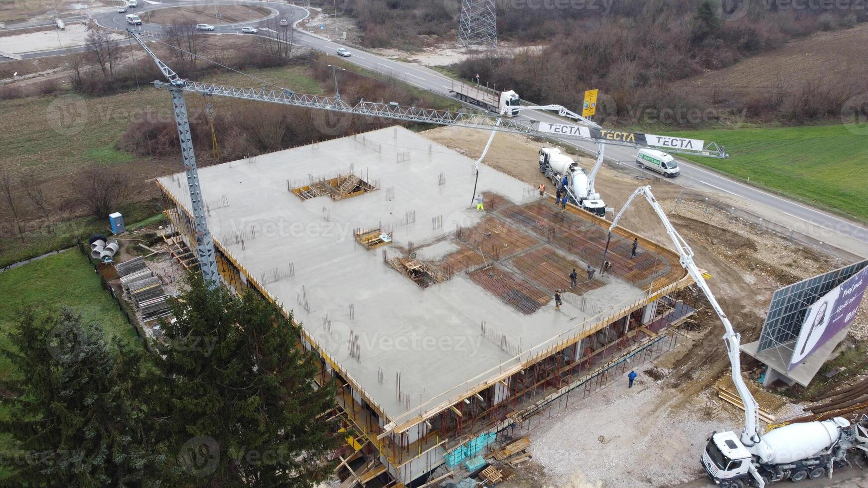 An aerial view captured by a drone showcasing the ongoing construction of a modern building, highlighting the work on the structure, scaffolding, and machinery on site photo