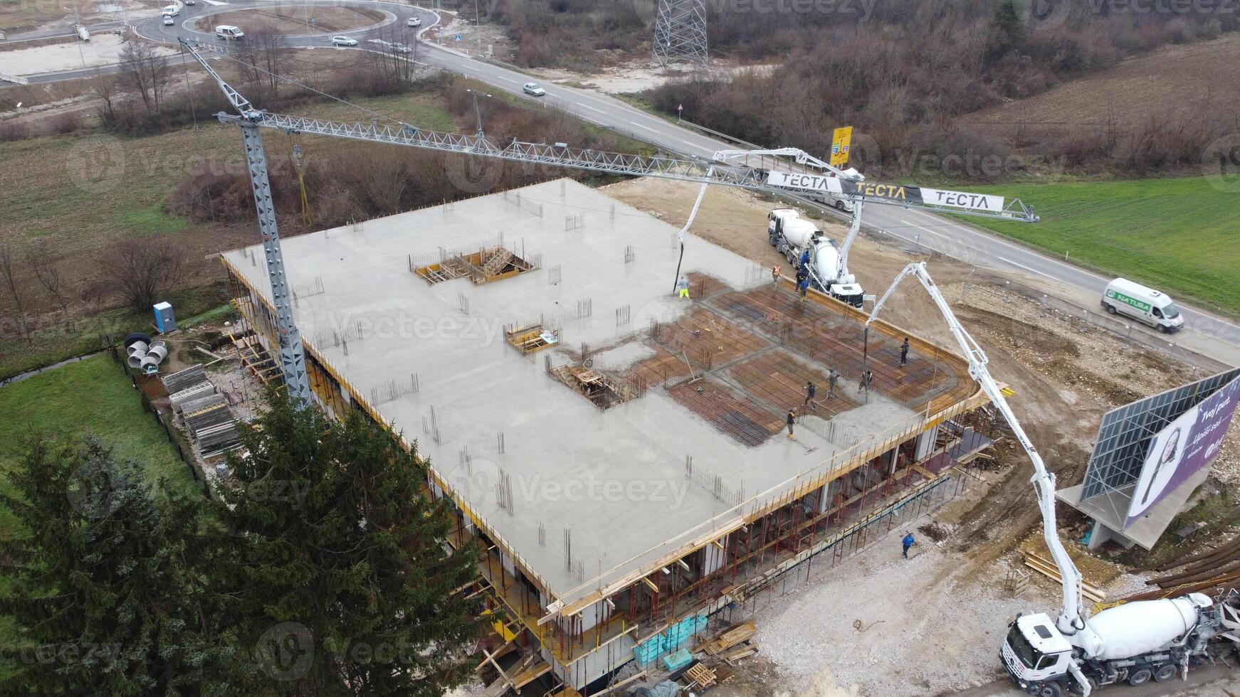 An aerial view captured by a drone showcasing the ongoing construction of a modern building, highlighting the work on the structure, scaffolding, and machinery on site photo