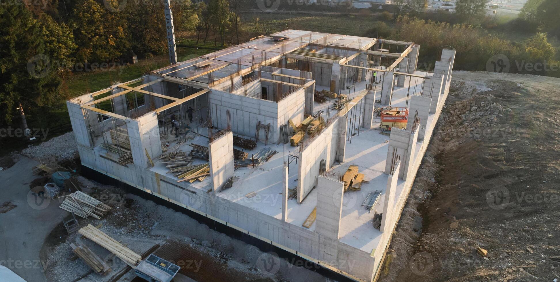 An aerial view captured by a drone showcasing the ongoing construction of a modern building, highlighting the work on the structure, scaffolding, and machinery on site photo