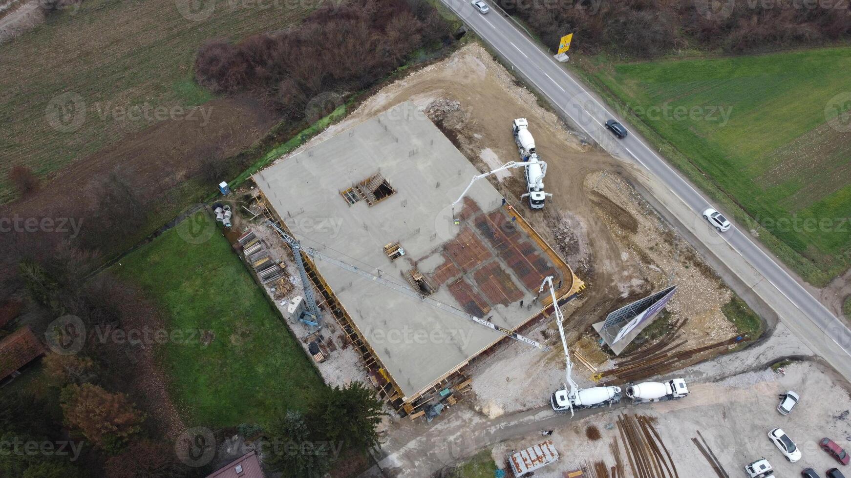 An aerial view captured by a drone showcasing the ongoing construction of a modern building, highlighting the work on the structure, scaffolding, and machinery on site photo
