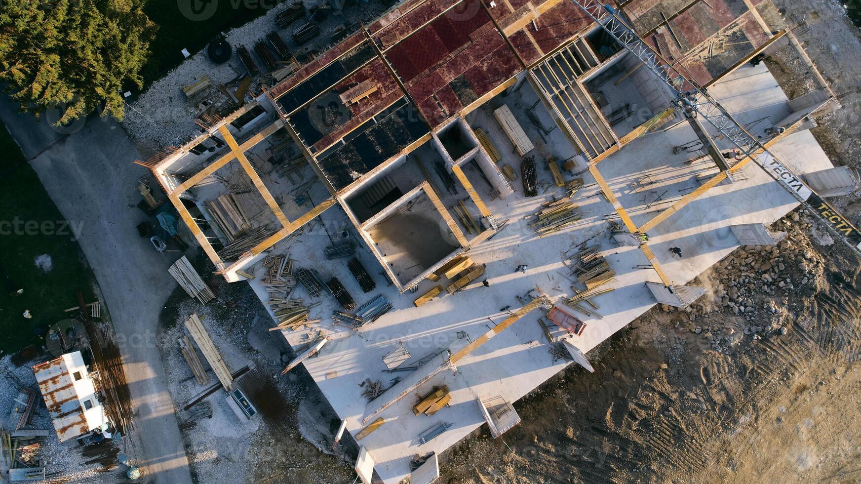 An aerial view captured by a drone showcasing the ongoing construction of a modern building, highlighting the work on the structure, scaffolding, and machinery on site photo