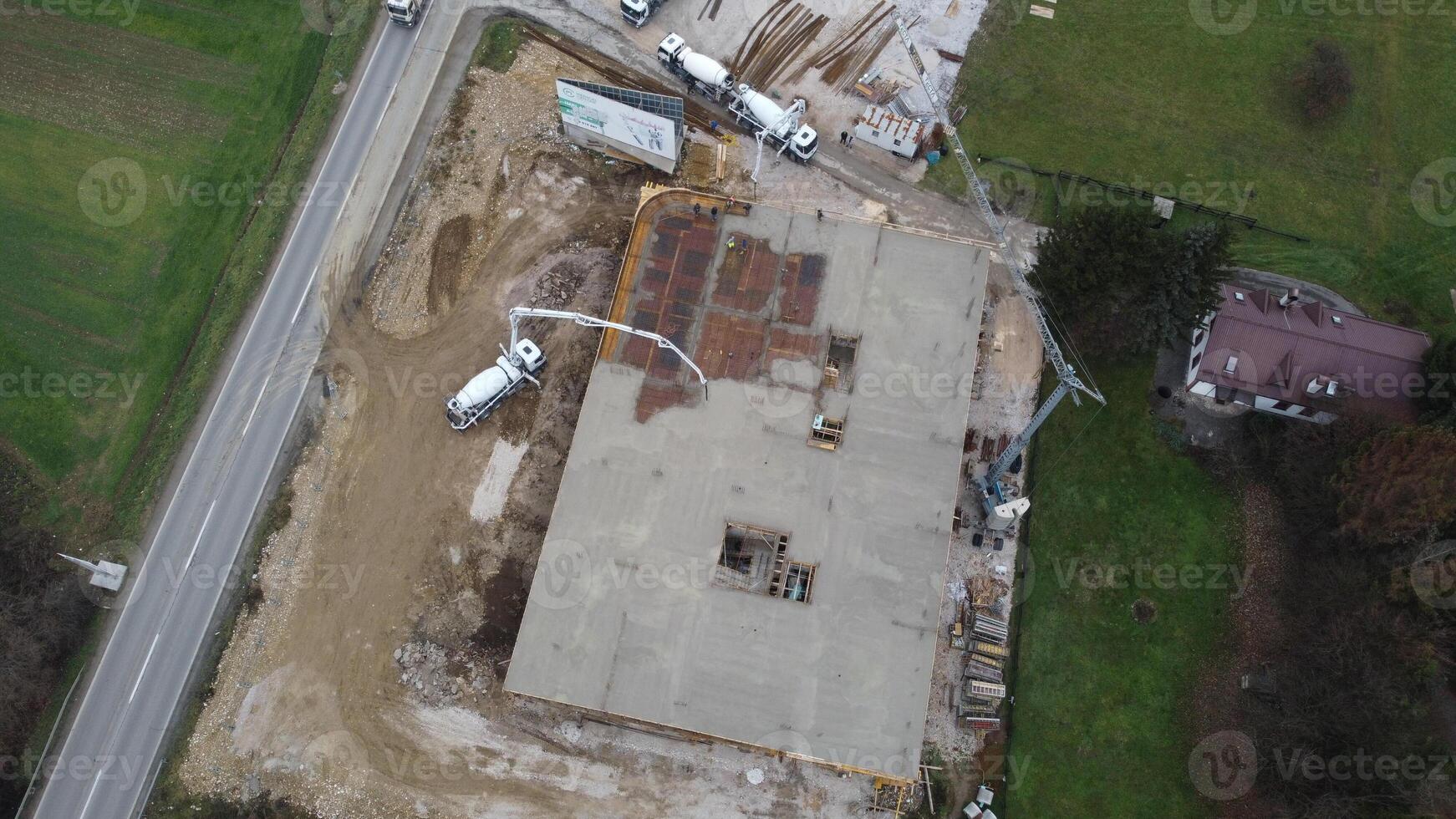 An aerial view captured by a drone showcasing the ongoing construction of a modern building, highlighting the work on the structure, scaffolding, and machinery on site photo