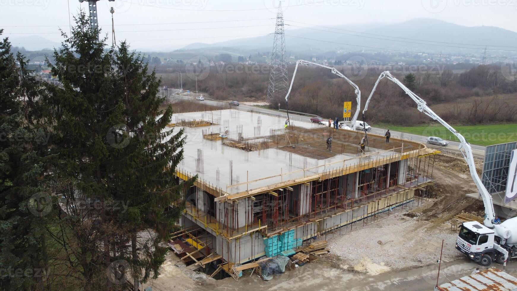 An aerial view captured by a drone showcasing the ongoing construction of a modern building, highlighting the work on the structure, scaffolding, and machinery on site photo
