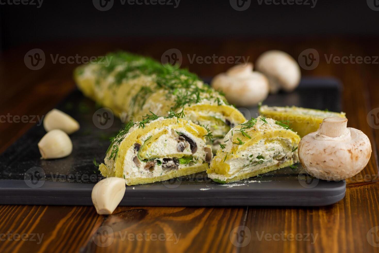 baked potato roll with cottage cheese filling with garlic and mushrooms, on a dark wooden table photo