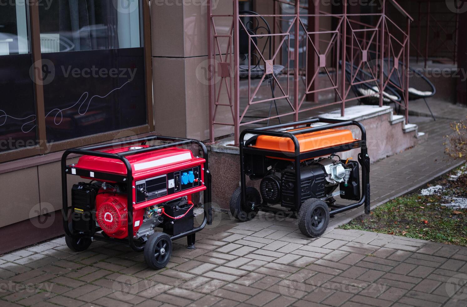 Two portable generators placed outside a building, showcasing power solutions for outdoor and emergency use photo