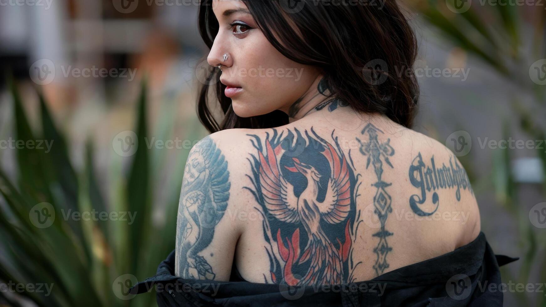 Woman displays phoenix tattoo on her back, symbolizing rebirth and strength through personal expression. Tattoo inspiration concept photo