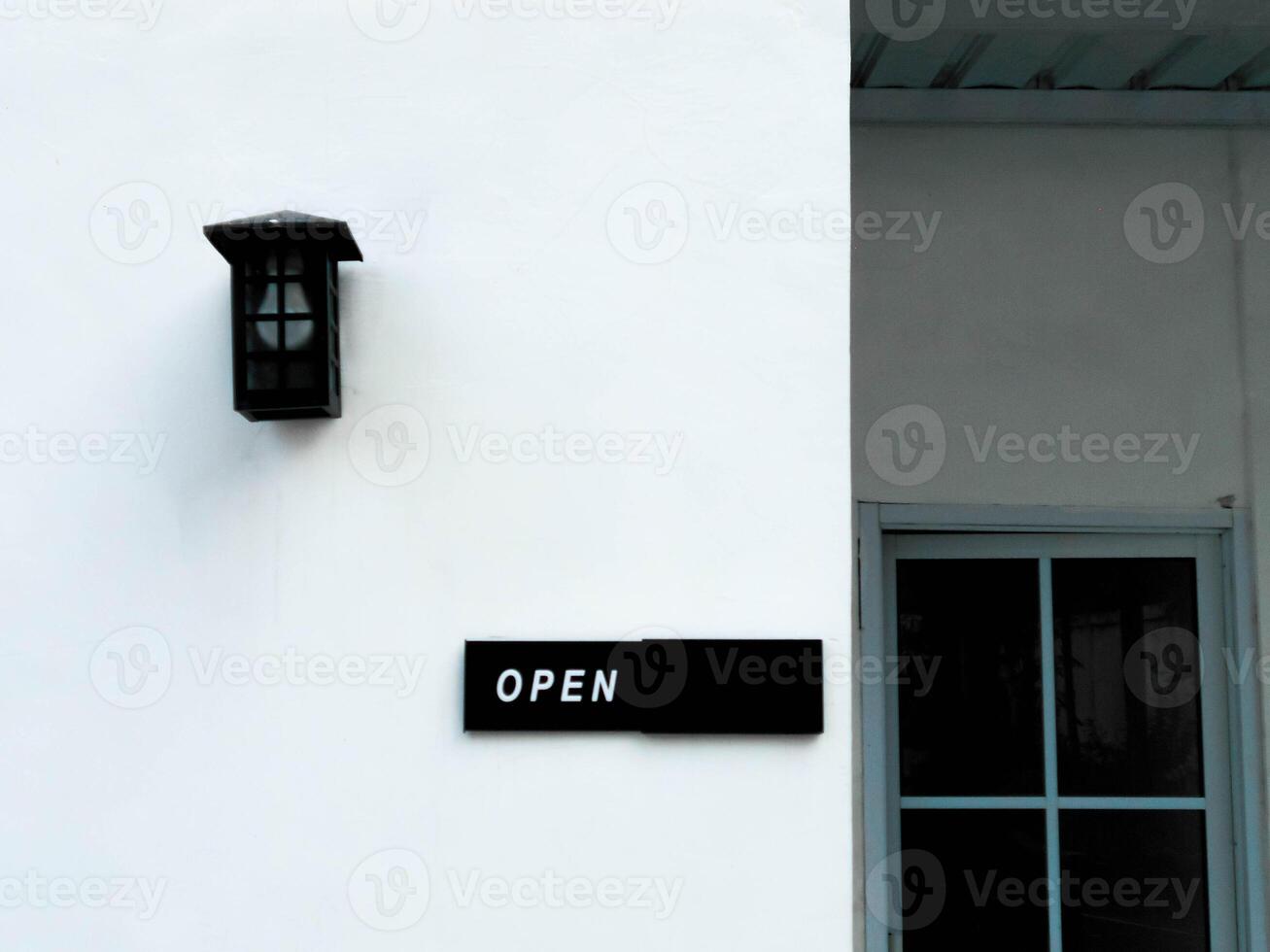 A white building with a black sign on the side photo