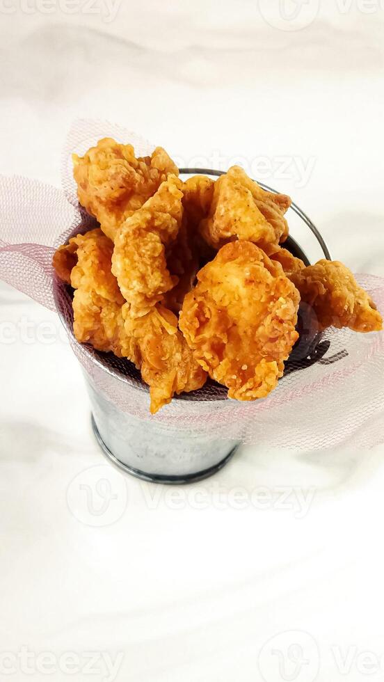 Popcorn chicken in a cup, crispy and golden, detailed and isolated, provided for snack food or fast food menu items photo