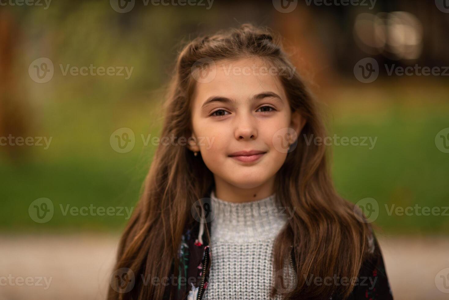 Portrait of a happy child girl outside looking at camera and smiling. photo