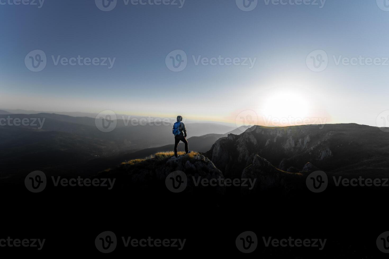 A person who hikers enjoys a break look at the top of the mountain, adventure travel. photo