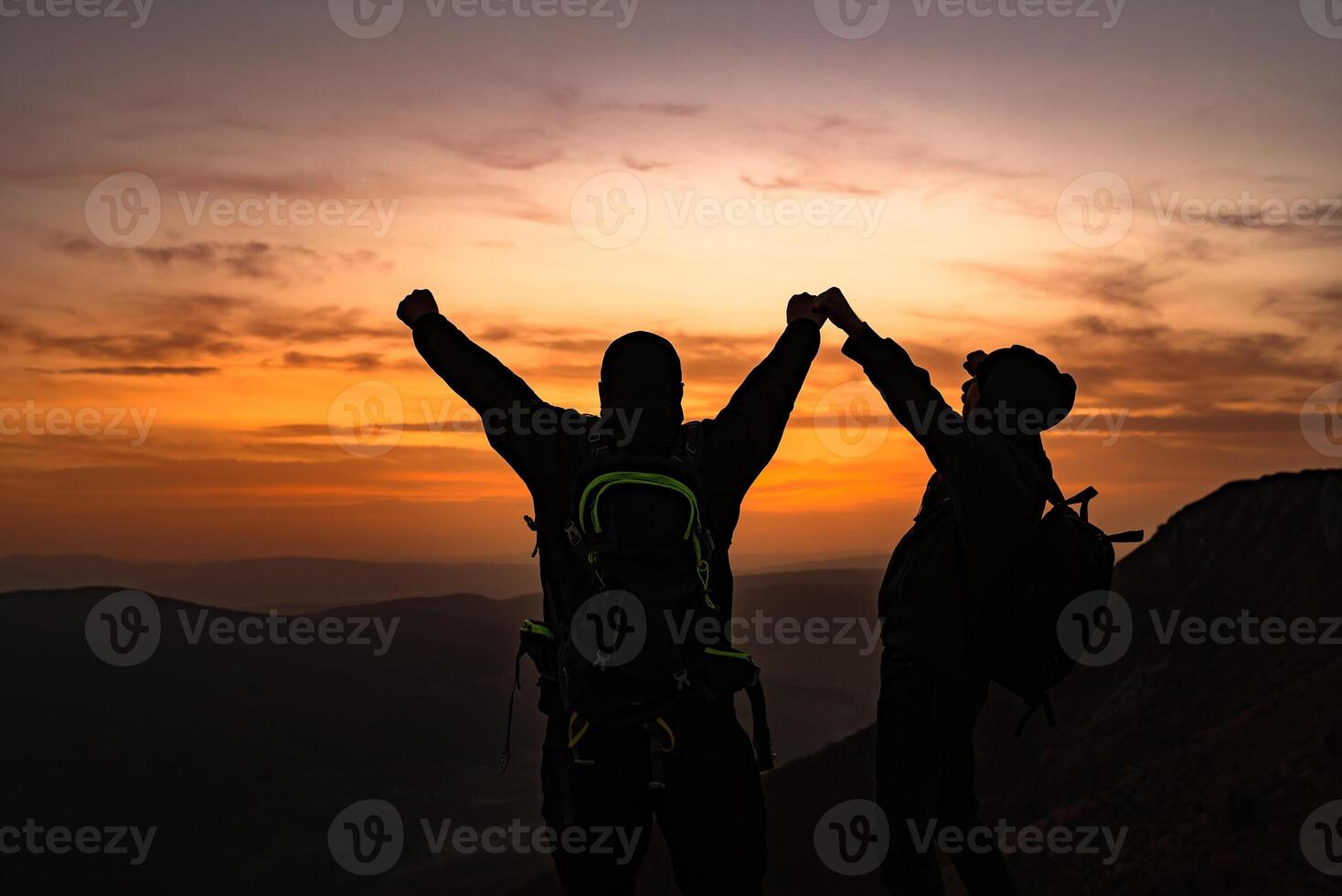 A happy hikers celebrating successful completed hiking route with arms up at the top of the mountain adventure travel. photo