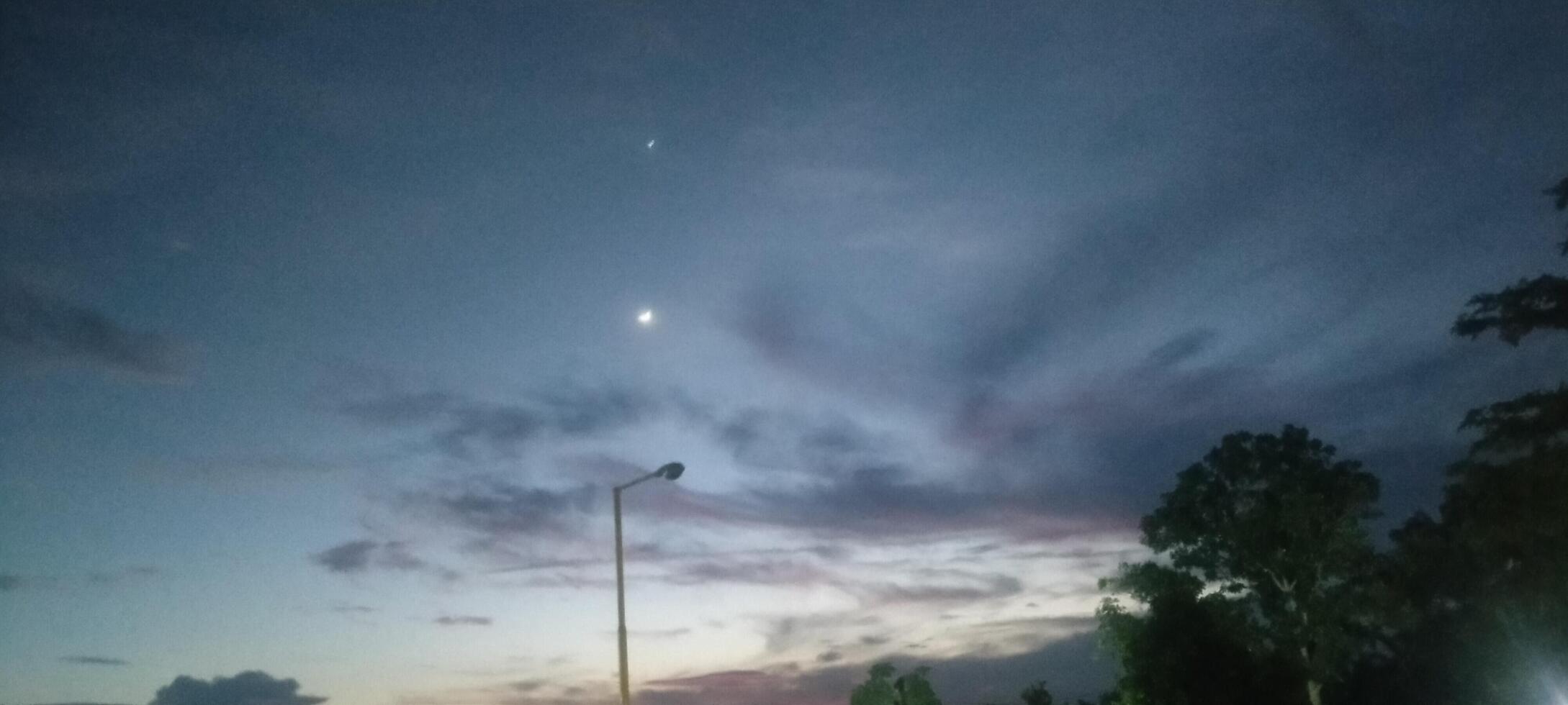 The atmosphere of the sky at night is a dazzling combination of dark blue, purple and orange photo
