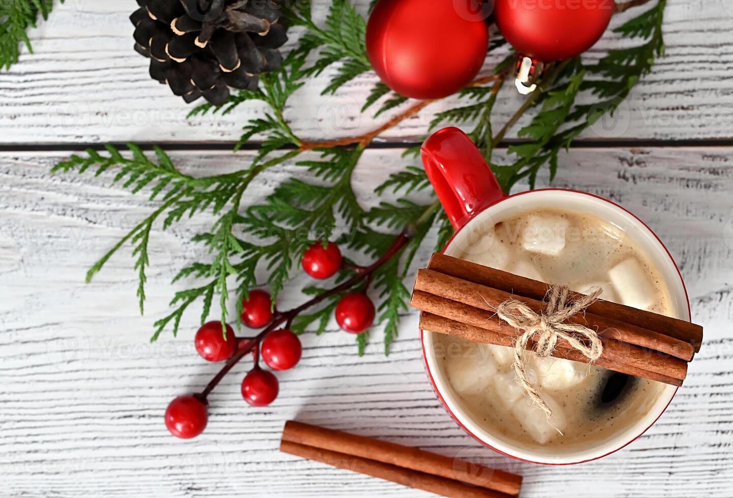 A delightful Christmas card adorned with charming toys, vibrant fir branches, and an exquisite garland, enhanced with scrumptious treats and aromatic cinnamon. photo