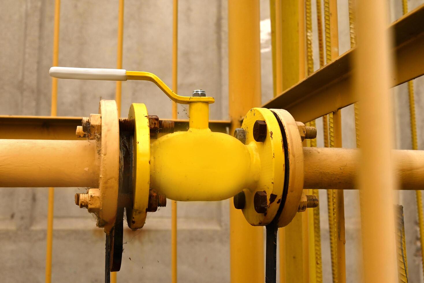 yellow gas pipe with a crane goes along the facade of a new multi-storey building. House connected to gas for domestic use photo