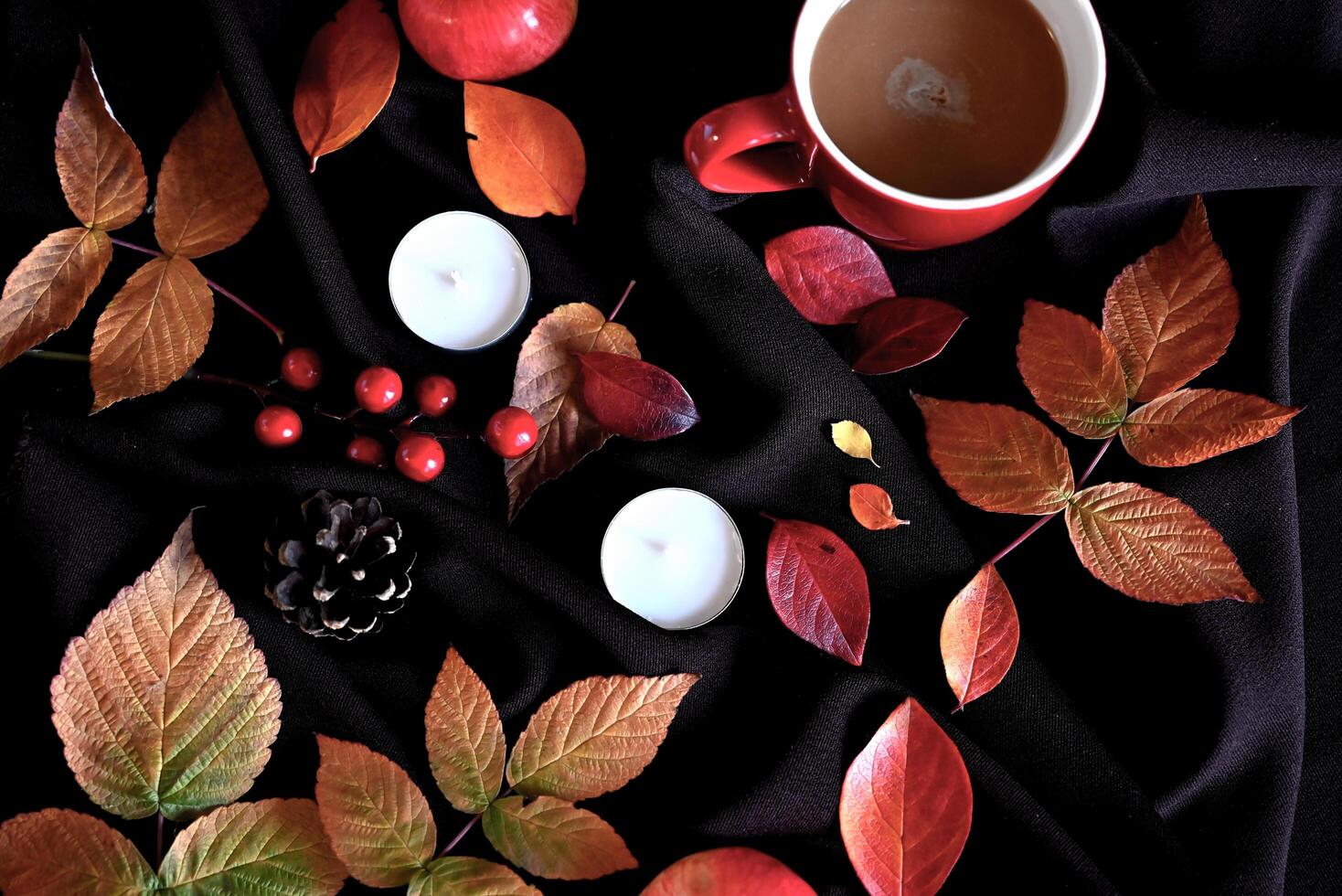 Autumn still life with a cup of coffee, candles and burgundy leaves photo