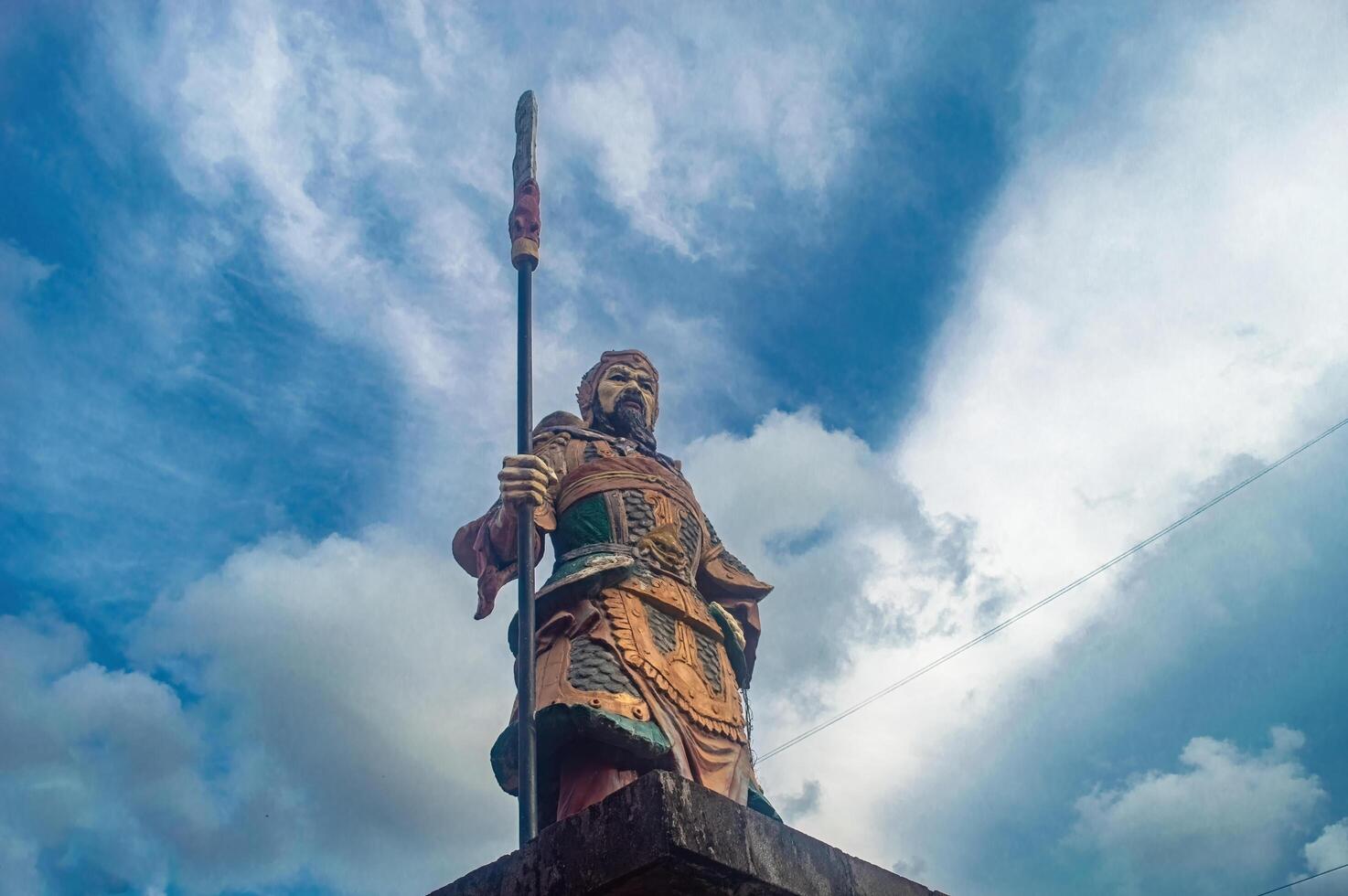 A majestic statue of a warrior holding a spear stands tall, symbolizing strength and heritage, often associated with Lunar or Chinese New Year celebrations. Indonesia, 17 November 2024 photo